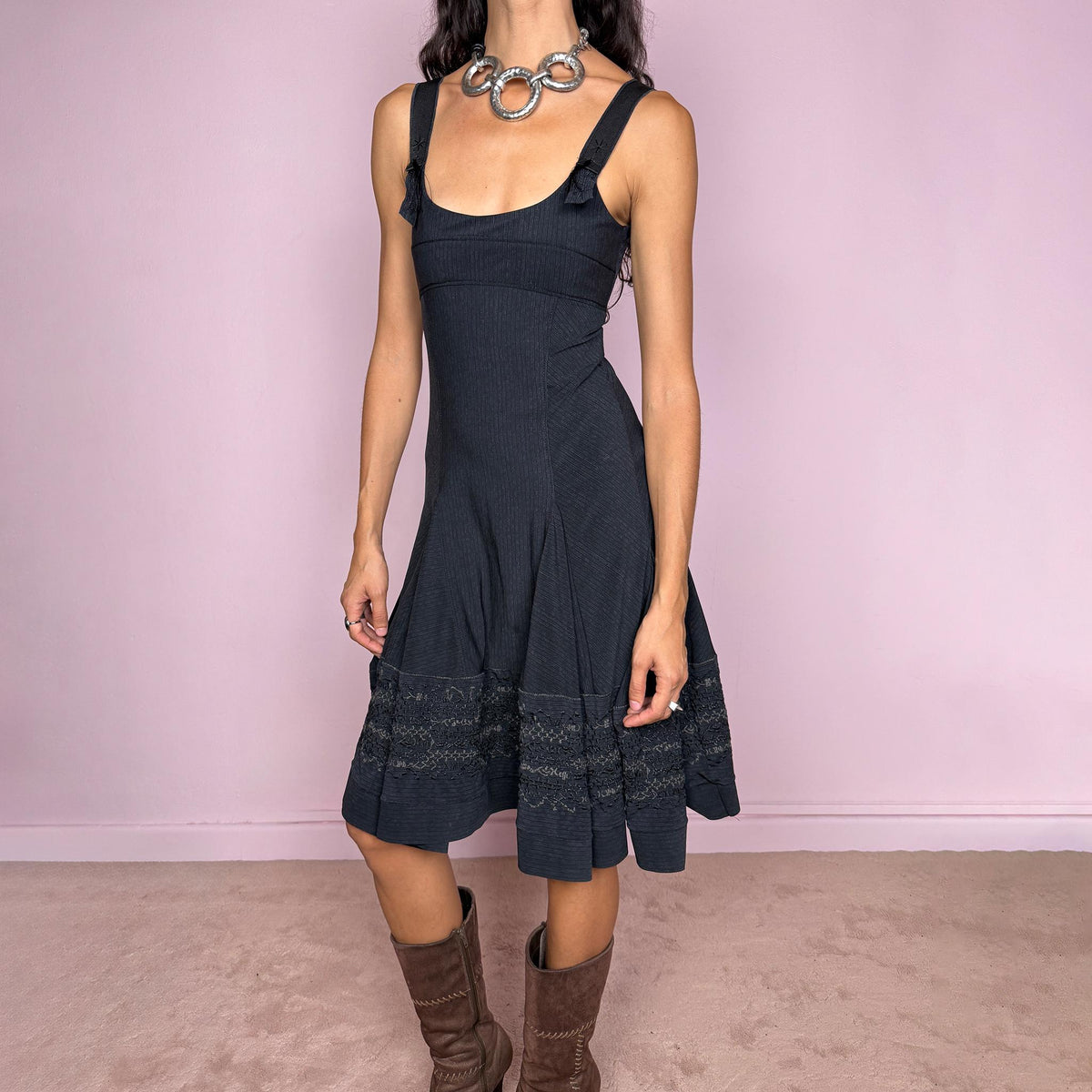 Vintage 2000s black midi dress by French label Marithé + François Girbaud, featuring a fitted sleeveless bodice with a scoop neckline and curved seam construction through the torso. The fabric has a subtle micro-pinstripe texture, while the silhouette flares from the hips into a structured A-line skirt with embroidered details. Made from a stretchy blend of 72% polyamide and 28% elastane. Excellent vintage condition.