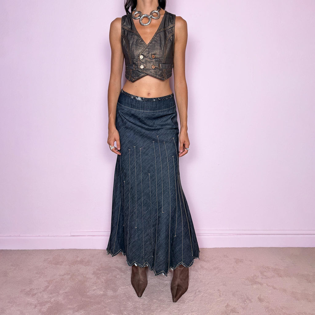 Vintage 2000s blue denim maxi skirt by Marithé + François Girbaud, from the Le Jean de Marithé + François Girbaud line. Made in Italy from a structured 77% cotton and 23% polyester blend. Featuring a side zip closure, contrast stitching, and a flared lower section with elongated vertical stitch detailing and a sculptural, pointed, frayed raw hem. Non-stretch. Can be worn mid-rise for size M. The architectural construction gives it an avant-garde designer aesthetic. Excellent vintage condition.