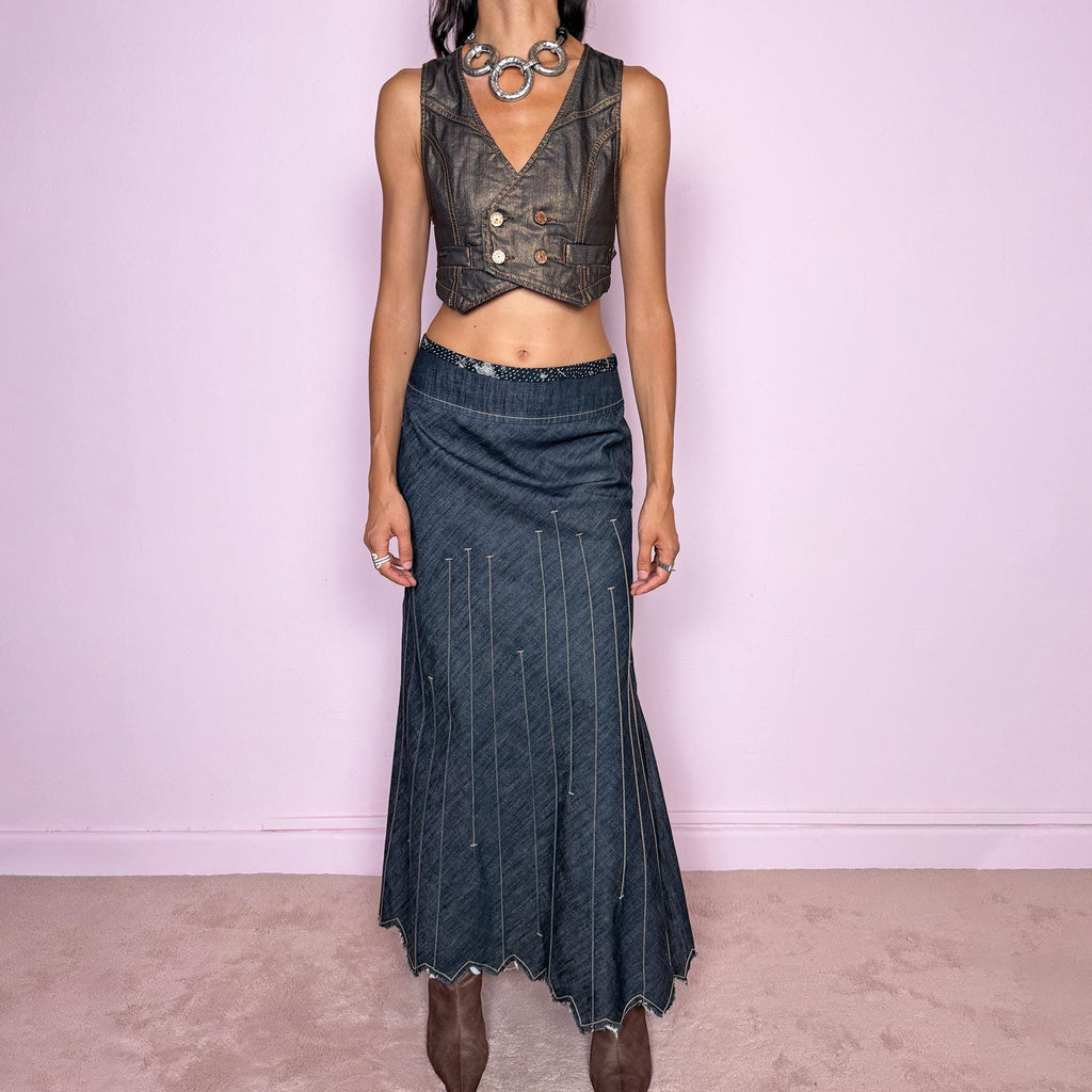 Vintage 2000s blue denim maxi skirt by Marithé + François Girbaud, from the Le Jean de Marithé + François Girbaud line. Made in Italy from a structured 77% cotton and 23% polyester blend. Featuring a side zip closure, contrast stitching, and a flared lower section with elongated vertical stitch detailing and a sculptural, pointed, frayed raw hem. Non-stretch. Can be worn mid-rise for size M. The architectural construction gives it an avant-garde designer aesthetic. Excellent vintage condition.