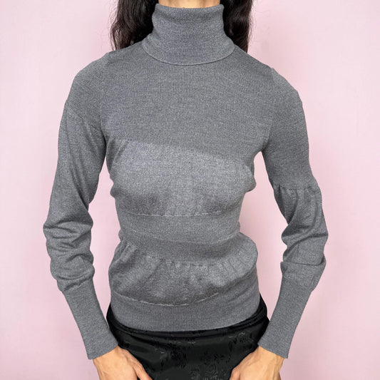 Avant garde vintage 2000s Italian designer gray turtleneck sweater by Moschino Cheap and Chic, crafted from 100% virgin wool and made in Italy. Sculptural knit design with ballooned panels contrasted by fitted sections, creating subtle volume and structure. Clean design typical of Moschino’s early-2000s tailoring, where quality materials and sharp construction took priority over graphics. Perfect for minimal 90s, office siren, or elevated everyday styling. Excellent vintage condition.