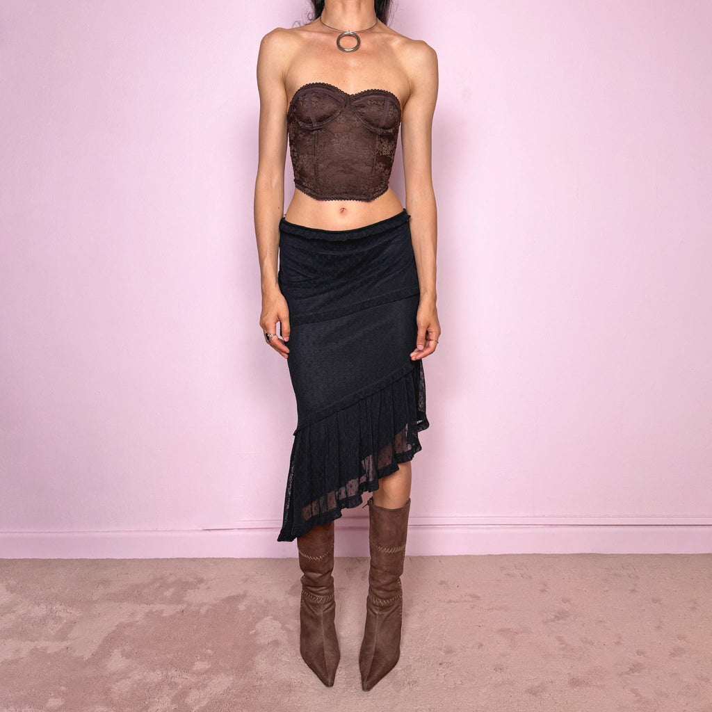 Vintage 2000s Moschino Jeans black lace asymmetric midi skirt made in Italy from a stretchy polyamide fabric. Features a low-rise, soft stretch waistband without elastic, delicate ruffle trim, layered asymmetric panels, and a sheer lace pleated hem. A dark romantic Y2K designer piece, perfect for elevated evening looks. Excellent vintage condition.