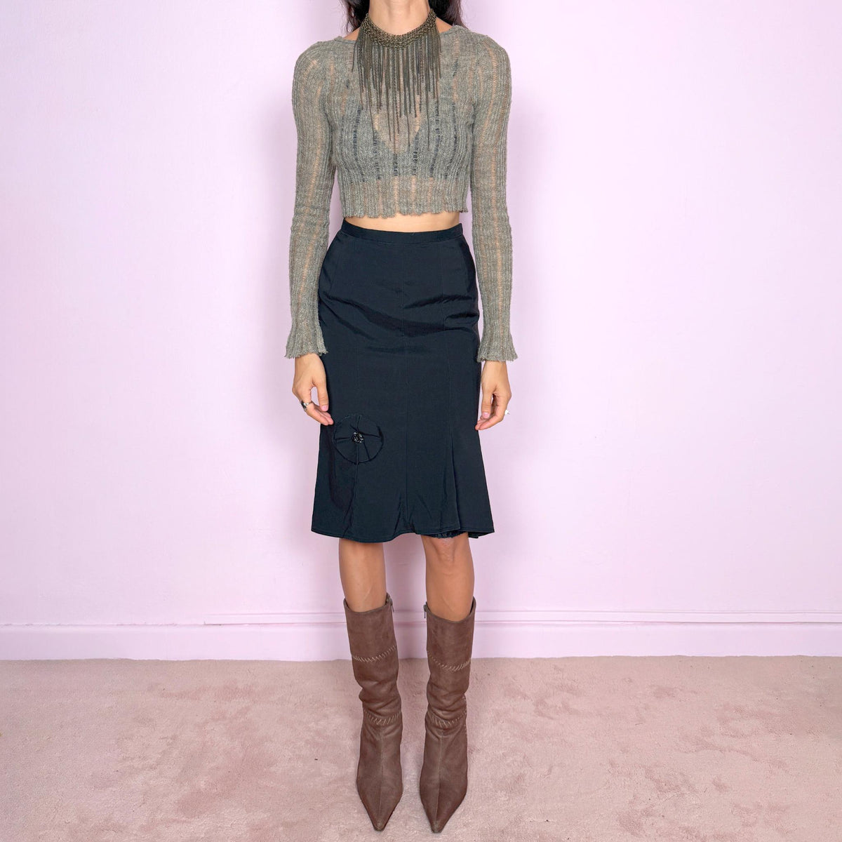 Vintage 2000s black midi skirt by Japanese designer Ritsuko Shirahama. Features a high-waisted, fitted silhouette with clean vertical seam construction, a softly flared hem, and a sculptural circular appliqué near the lower front. Finished with a back zip closure. Made in Japan from a non-stretch blend of 78% silk and 22% polyurethane, with a 100% polyester lining. Great vintage condition.