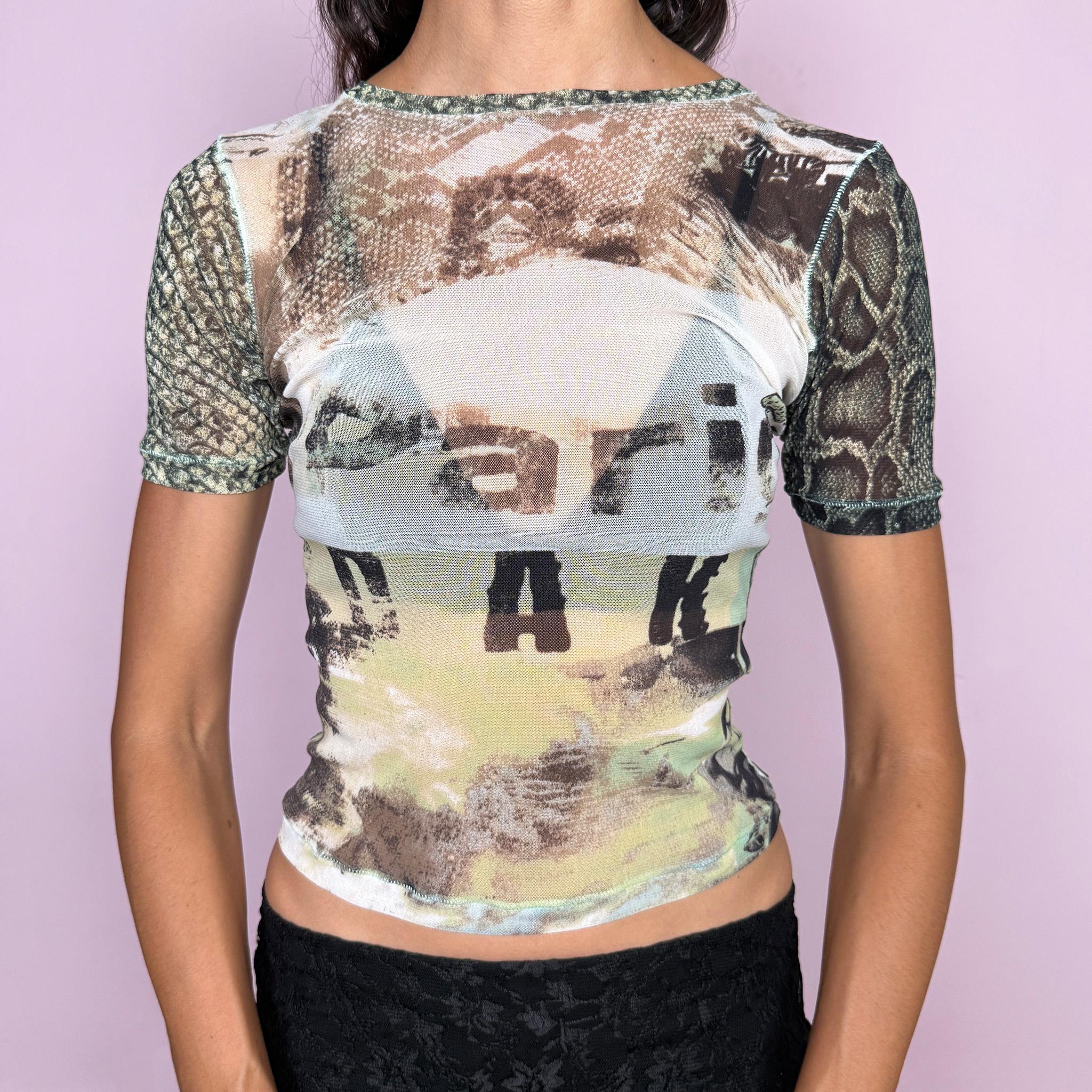Vintage 2000s Roberto Cavalli Freedom mesh top crafted from semi-sheer, stretchy mesh with a fitted silhouette and short sleeves. It features an eclectic mixed print that contrasts earthy photographic and snakeskin-inspired graphics at the front with a vibrant retro floral print across the back. Lightweight, sheer, and body-skimming, with a distinctly maximalist Y2K Cavalli feel. Made in Italy from 100% polyamide. Excellent vintage condition.