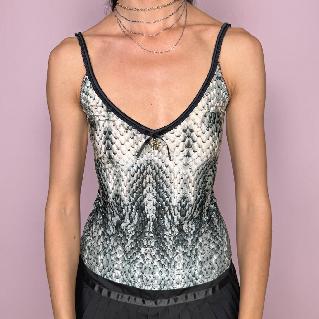 Vintage 2000s Roberto Cavalli Underwear white cami top in a striking black, gray, and greenish snake/reptile print with a fitted stretchy silhouette, black trims, and a delicate front bow detail with a gold-tone Cavalli charm. Made in Italy from a 75% polyamide and 25% elastane blend, with a flattering deep V neckline and thin straps. A sensual Y2K piece for lingerie-as-outerwear looks. Excellent vintage condition.