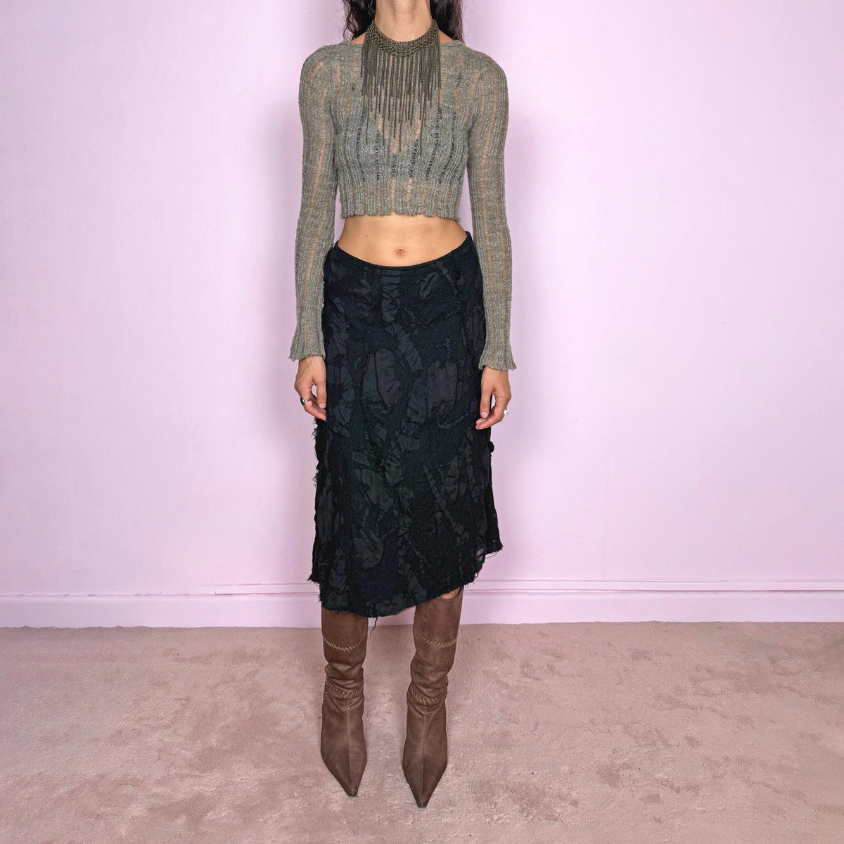 Vintage 2000s black midi skirt by Belgian fashion label Sarah Pacini, made in Italy from 100% wool with a 100% cotton lining. Features a flared A-line silhouette with a textured wool outer layer constructed from irregular cut-out and appliqué-like panels, creating an organic, distressed surface throughout. Finished with a side zip closure and no stretch. Can be worn high-waisted for size S or slightly lower on the waist for size XS. Excellent vintage condition.