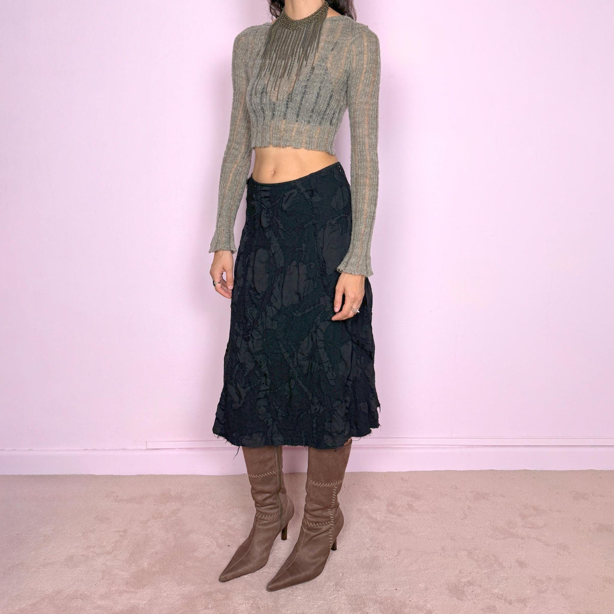 Vintage 2000s black midi skirt by Belgian fashion label Sarah Pacini, made in Italy from 100% wool with a 100% cotton lining. Features a flared A-line silhouette with a textured wool outer layer constructed from irregular cut-out and appliqué-like panels, creating an organic, distressed surface throughout. Finished with a side zip closure and no stretch. Can be worn high-waisted for size S or slightly lower on the waist for size XS. Excellent vintage condition.