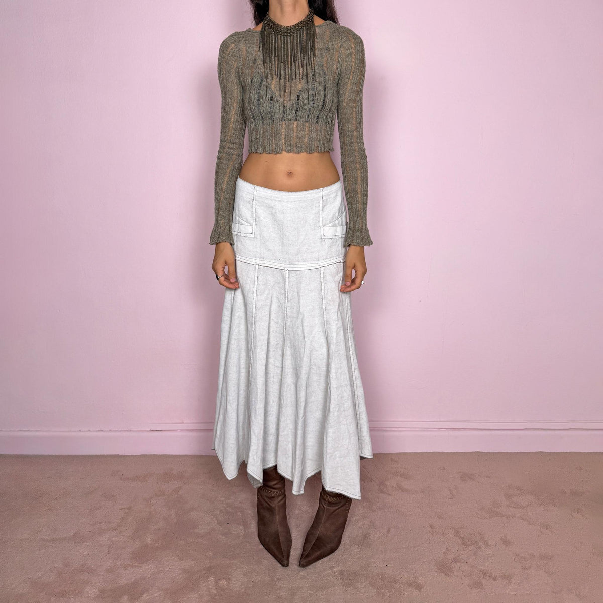 Vintage 2000s greyish-white maxi skirt by Belgian label Sarah Pacini, made in Italy from a non-stretch ramie blend. Features a fitted upper section, contrast topstitching, a back zip, a paneled flared silhouette, and an irregular handkerchief hem. Softly distressed, washed finish with a painted effect. Can be worn mid-rise for size S or lower on the waist for size XS. Excellent vintage condition.