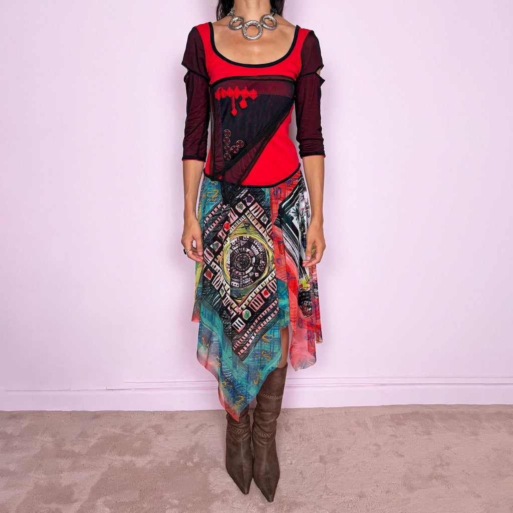 Vintage 2000s Save The Queen dress crafted from a stretchy semi-sheer mesh fabric with a bold graphic design. Designed in a fitted statement silhouette, it features a vivid red and black upper body with half sleeves and layered asymmetric panels that fall into a striking mixed-print skirt with abstract, geometric and hand-drawn motifs in red, turquoise, yellow, black and white tones. A highly visual Italian Y2K piece with an art-to-wear feel, perfect for a dramatic maximalist 2000s look.