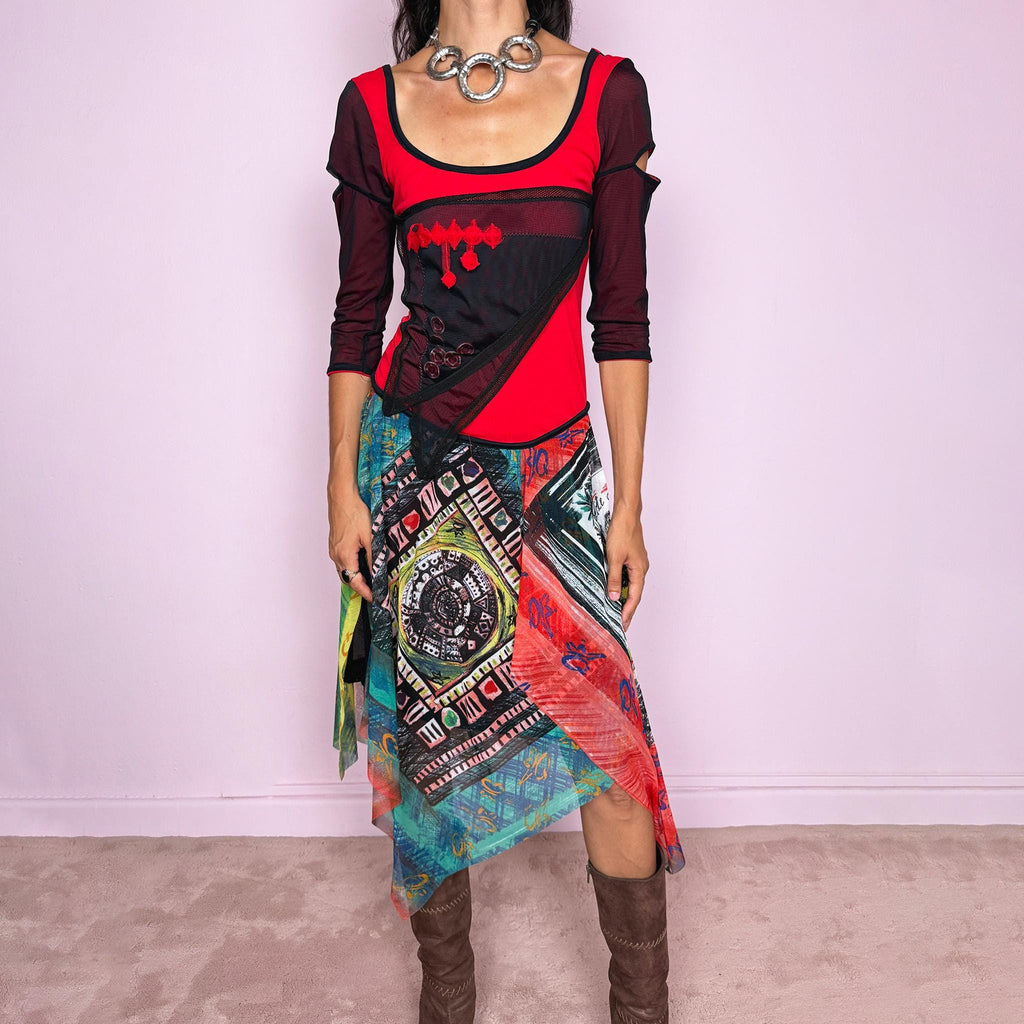 Vintage 2000s Save The Queen dress crafted from a stretchy semi-sheer mesh fabric with a bold graphic design. Designed in a fitted statement silhouette, it features a vivid red and black upper body with half sleeves and layered asymmetric panels that fall into a striking mixed-print skirt with abstract, geometric and hand-drawn motifs in red, turquoise, yellow, black and white tones. A highly visual Italian Y2K piece with an art-to-wear feel, perfect for a dramatic maximalist 2000s look.