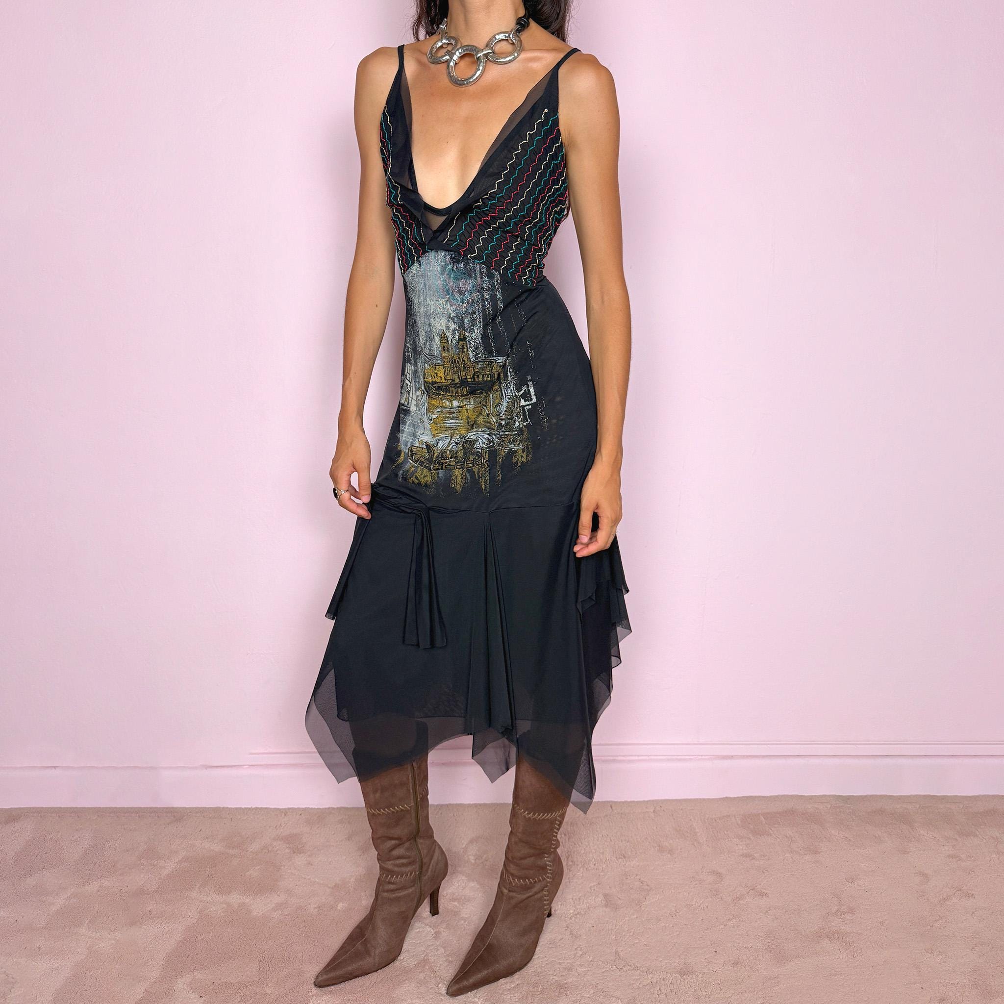 Vintage 2000s Save The Queen dress with semi-sheer mesh details and a sculptural asymmetric silhouette. Designed with thin straps, a deep V neckline, a fitted embroidered bodice with colorful zigzag stitching and a striking architectural graphic print across the front, falling into a layered black skirt with uneven sheer mesh panels and soft draped movement. A rare Italian Y2K statement piece with a dark romantic art-to-wear feel, balancing gothic fairycore