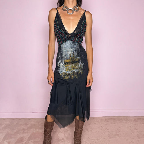 Vintage 2000s Save The Queen dress with semi-sheer mesh details and a sculptural asymmetric silhouette. Designed with thin straps, a deep V neckline, a fitted embroidered bodice with colorful zigzag stitching and a striking architectural graphic print across the front, falling into a layered black skirt with uneven sheer mesh panels and soft draped movement. A rare Italian Y2K statement piece with a dark romantic art-to-wear feel, balancing gothic fairycore