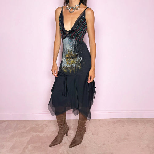 Vintage 2000s Save The Queen dress with semi-sheer mesh details and a sculptural asymmetric silhouette. Designed with thin straps, a deep V neckline, a fitted embroidered bodice with colorful zigzag stitching and a striking architectural graphic print across the front, falling into a layered black skirt with uneven sheer mesh panels and soft draped movement. A rare Italian Y2K statement piece with a dark romantic art-to-wear feel, balancing gothic fairycore, perfect for artistic parties and evenings. Made i