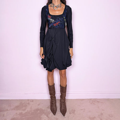 Vintage 2000s black long-sleeve mini dress by Italian label Save the Queen, made in Italy. Featuring a fitted stretchy bodice with a scoop neckline, layered textile appliqué detailing across the chest, and a sculptural draped bubble skirt with gathered volume and asymmetric folds. The sleek bodice and exaggerated balloon silhouette create an avant-garde, deconstructed look. Composition label is missing, so the exact fabric is unknown. Excellent vintage condition.