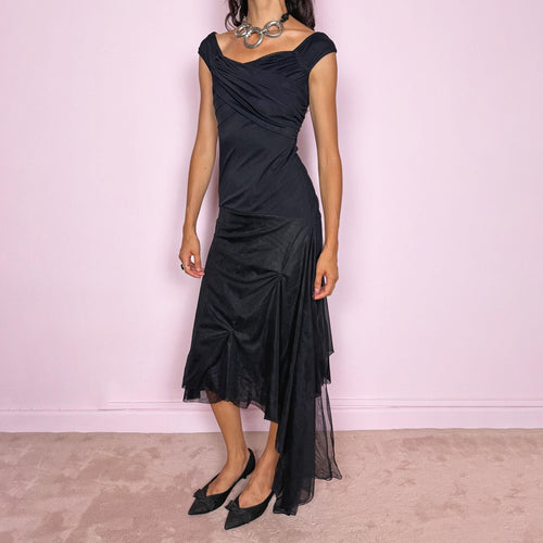 Vintage 2000s Save The Queen black midi dress with semi-sheer mesh layering and a sculptural asymmetric silhouette. It features a softly draped off-shoulder neckline, short cap sleeves, a fitted stretch body with diagonal ruching through the bust and waist, and an asymmetric layered skirt with sheer mesh panels, gathered details, and a long cascading side drape for dramatic movement. A rare Italian Y2K statement piece with a dark romantic evening feel, perfect for elegant parties and occasions.