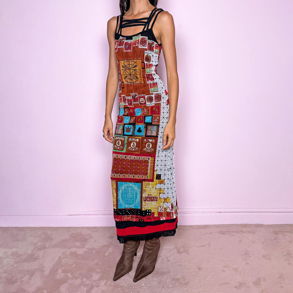 Vintage 2000s Save the Queen maxi dress, made in Italy from stretchy 100% polyamide mesh with a black mesh lining. Featuring an intricate multicolored graphic print with abstract symbols, game-inspired motifs, and richly layered artwork throughout, framed by strappy black mesh detailing across the neckline and shoulders. The long, fitted silhouette and highly detailed print give it a distinctive maximalist, art-to-wear feel characteristic of Y2K Italian fashion.