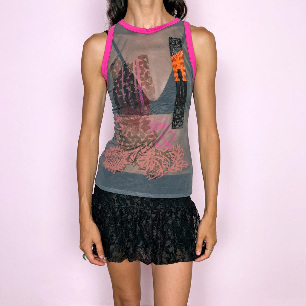 Vintage 2000s Save the Queen sleeveless sheer mesh top featuring an eclectic mixed graphic print in gray with vivid fuchsia contrast trim, intricate embroidery, and genuine leather appliqué inserts across the front, plus textured geometric detailing throughout the back. Perfect for bold, deconstructed summer outfits. Made in Italy from 100% polyamide with leather inserts. Excellent vintage condition.
