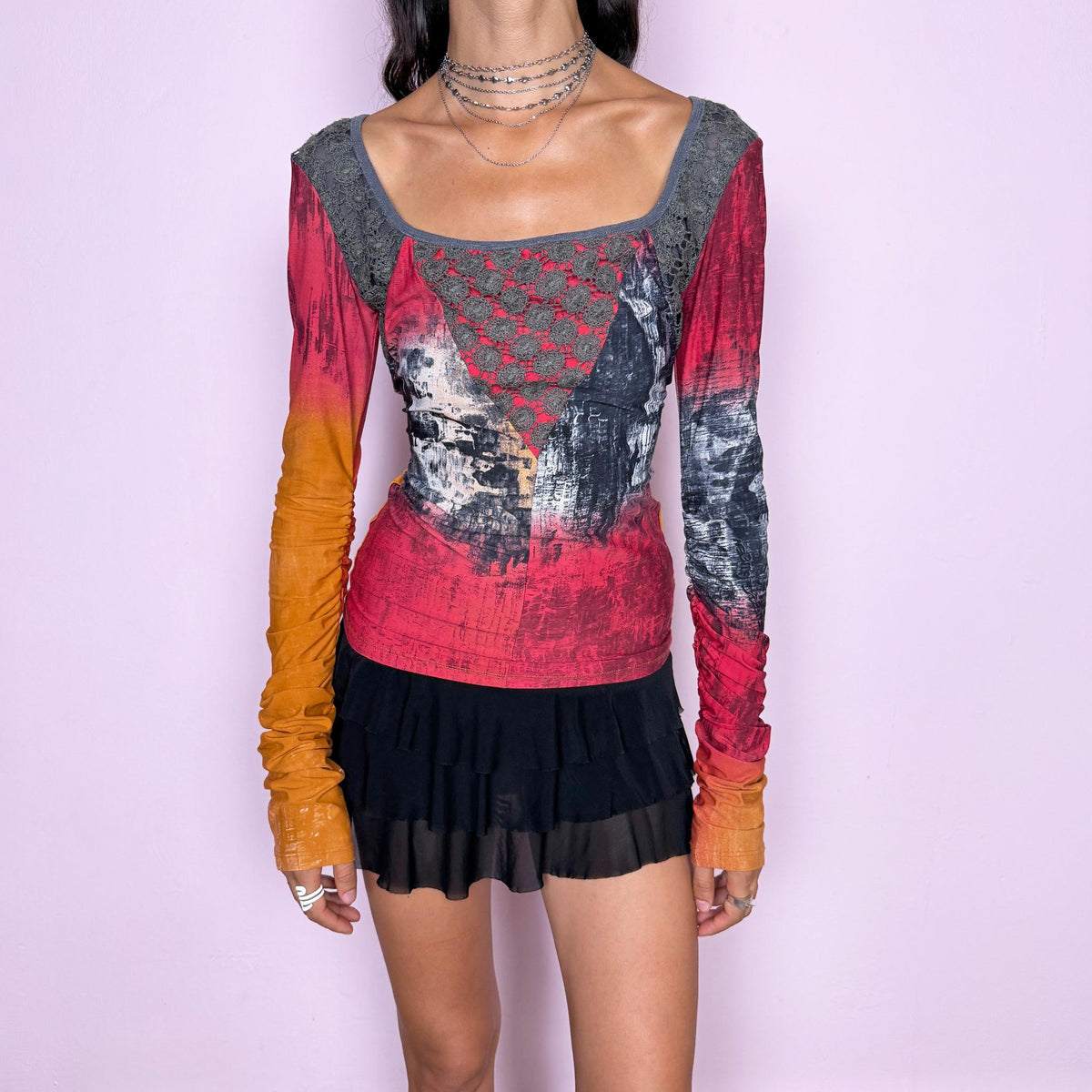 Vintage 2000s long-sleeve top by Italian label Save the Queen, featuring a fitted, body-skimming silhouette, scoop neckline, contrasting lace paneling across the upper bodice, and an abstract painterly print in red, orange, charcoal, and gray tones. Designed with extra-long ruched sleeves for a bold, maximalist aesthetic. Made in Italy from a stretchy 80% polyamide and 20% elastane blend. Excellent vintage condition.