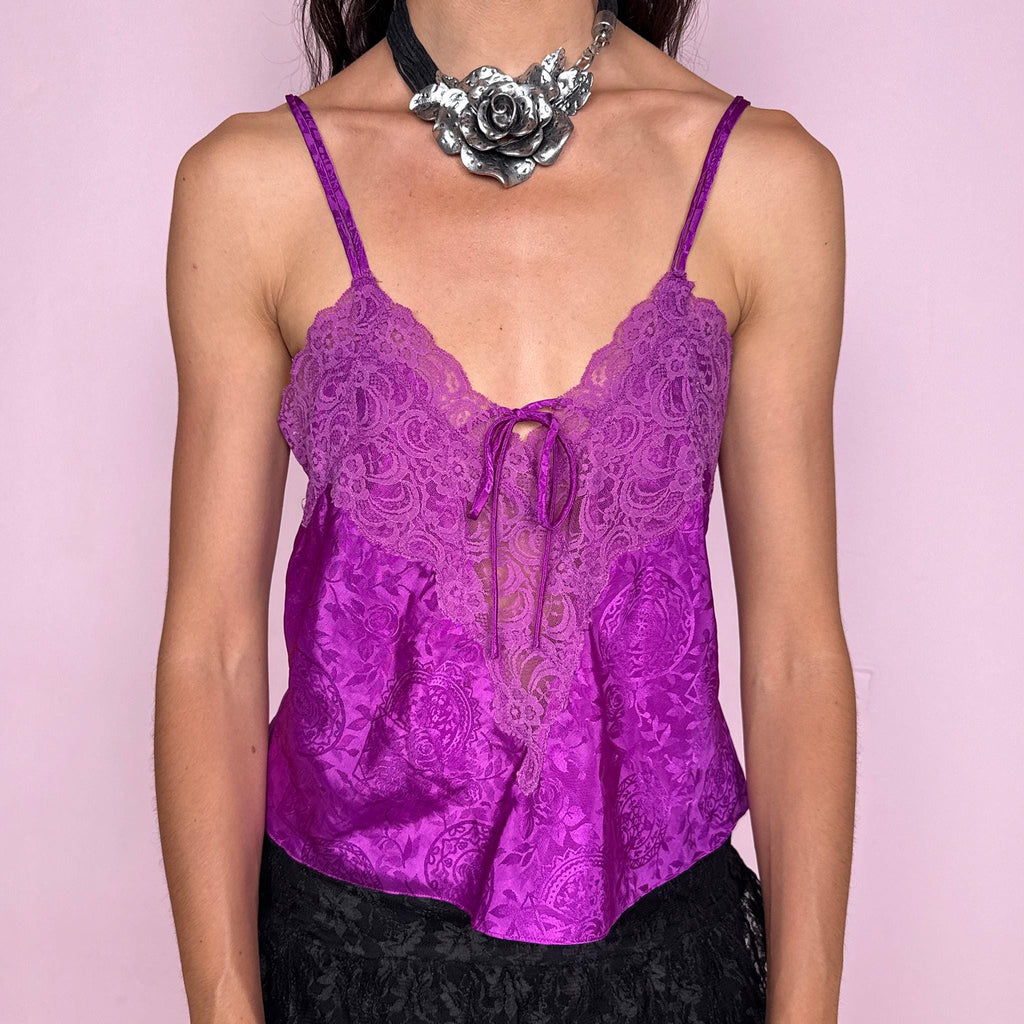Vintage 2000s romantic Victoria’s Secret purple satin lingerie cami top with floral lace bust, sheer front lace insert, vivid lilac-purple paisley floral jacquard, adjustable spaghetti straps, and small neckline tie. Lightweight, perfect as a feminine statement piece for evening or summer styling. Composition label is missing, so the exact fabric is unknown. Excellent vintage condition.