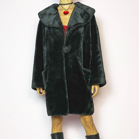 The Vintage 90s Black Faux Fur Coat showcases a faux fur material for a sophisticated and cozy winter style. It features a plush oversized collar, a chic fabric-covered button closure, and pockets. Perfect for winter outings or evening events. A statement 90s coat made from a polyester faux fur blend. Excellent vintage condition.