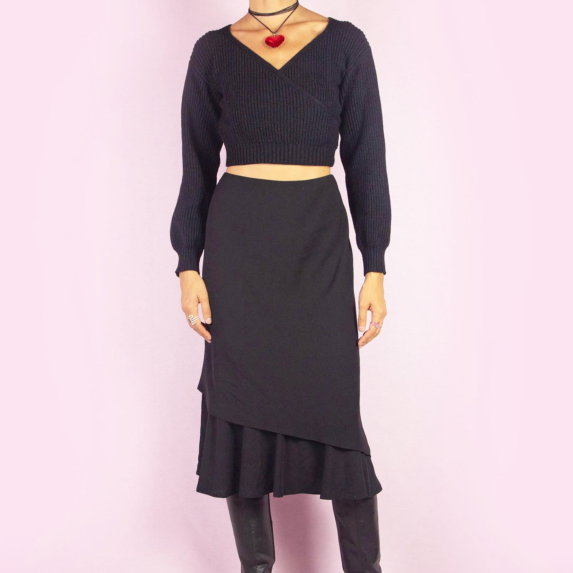 The Vintage 90s Black Layered Midi Skirt showcases a layered design with a flared underlayer peeking out for an elegant silhouette. Featuring an elastic waist, this midi-length skirt is perfect for both office wear and evening occasions.