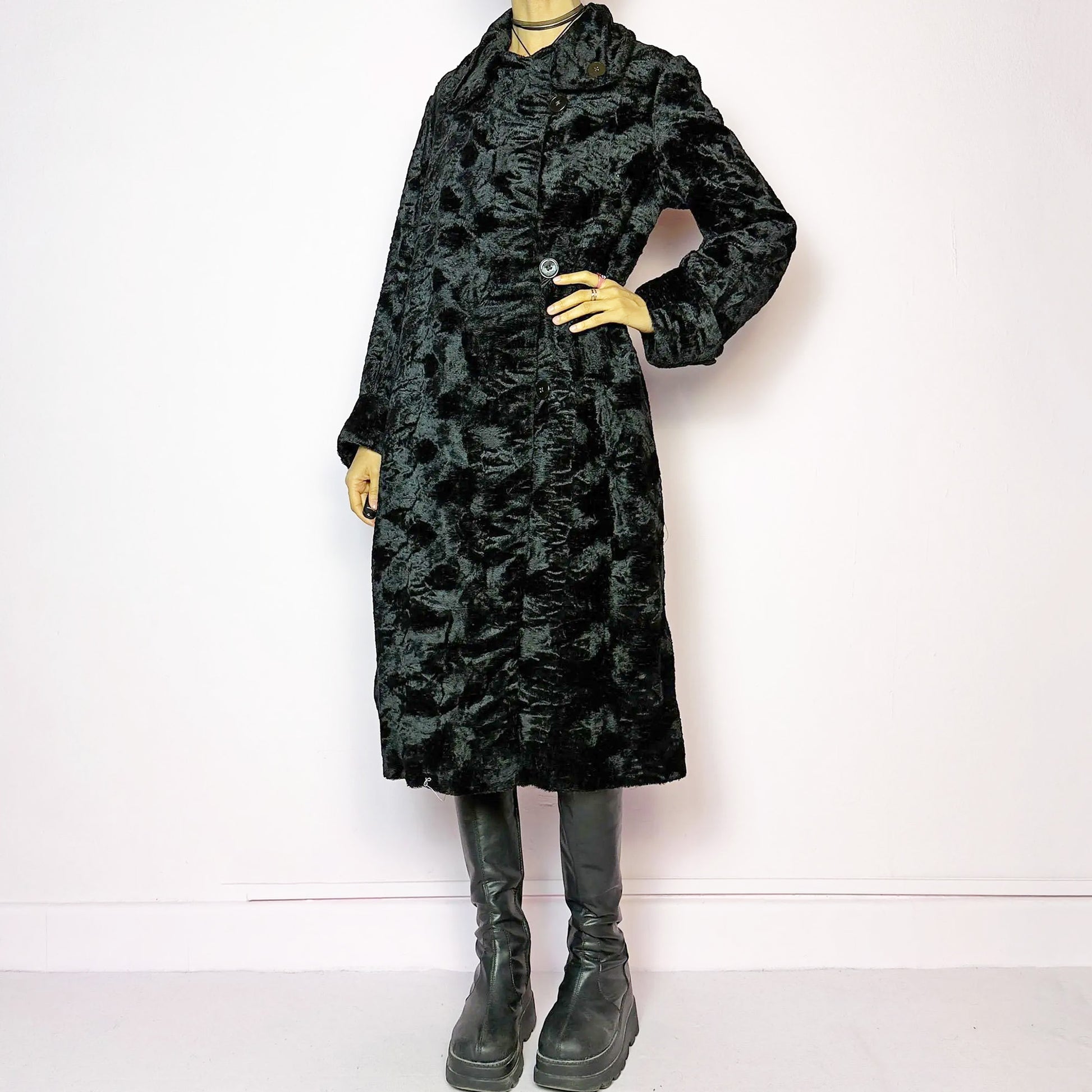 The Vintage 90s Black Faux Fur Long Coat features a plush faux fur exterior for a cozy feel. Designed with a button front closure, it includes long sleeves and pockets. Its longline silhouette makes it a chic and warm choice for winter evenings and casual outings. Made from a faux fur blend. Great vintage condition.