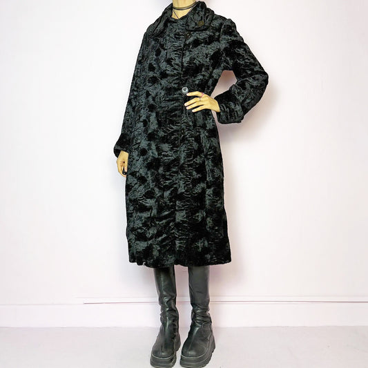 The Vintage 90s Black Faux Fur Long Coat features a plush faux fur exterior for a cozy feel. Designed with a button front closure, it includes long sleeves and pockets. Its longline silhouette makes it a chic and warm choice for winter evenings and casual outings. Made from a faux fur blend. Great vintage condition.