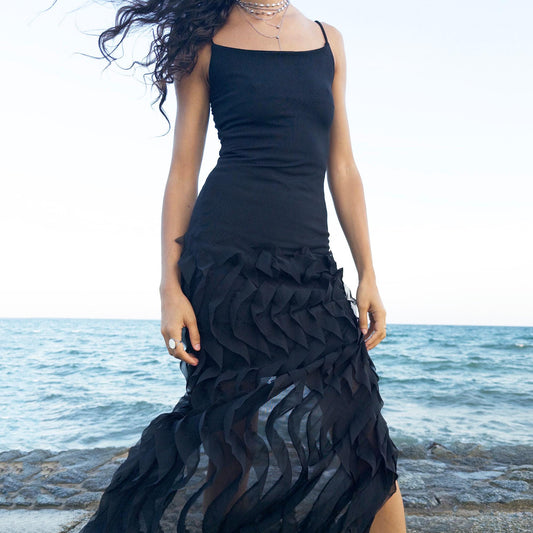 The vintage 90s black mesh midi dress is a sculptural piece with sheer wave appliqué layered across the skirt, minimalist neckline, and a back slit for fluidity. Its body-skimming silhouette fuses quiet sensuality with architectural edge. Ideal for city nights, gallery parties, or modern cocktail looks. An avant garde archive find made in the USA from a stretchy polyester blend. Excellent vintage condition.