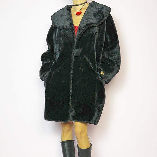The Vintage 90s Black Faux Fur Coat showcases a faux fur material for a sophisticated and cozy winter style. It features a plush oversized collar, a chic fabric-covered button closure, and pockets. Perfect for winter outings or evening events. A statement 90s coat made from a polyester faux fur blend. Excellent vintage condition.