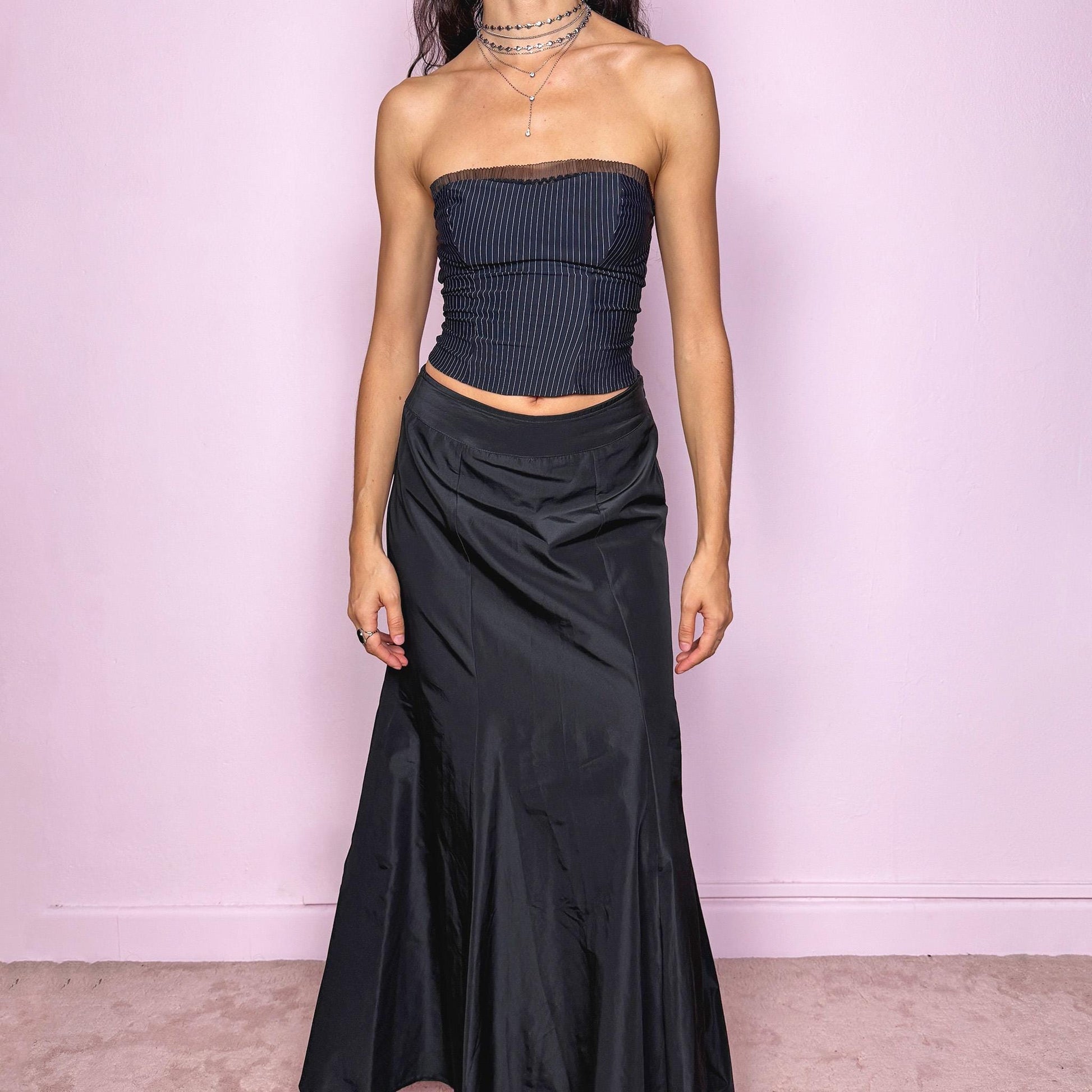 This stunning vintage 90s black silk-blend maxi skirt features a sculpted mermaid silhouette with a side zipper closure and no stretch. Made in Italy, it drapes fluidly for a dramatic, refined look, perfect for gala nights, prom, or dark romantic styling. Fits high-waisted for size S. Made from a silk blend non-stretch fabric. Excellent vintage condition.