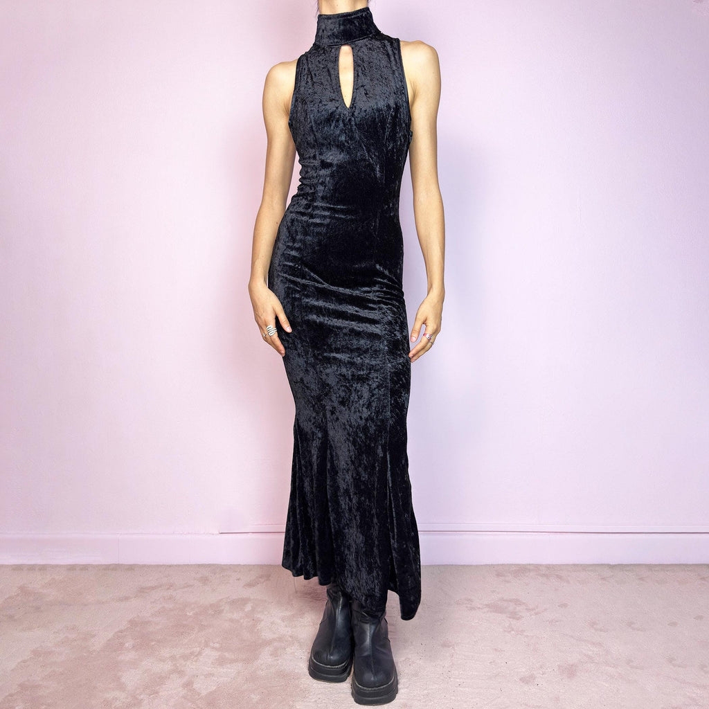 This vintage 90s black maxi dress is cut from plush stretch velvet with a sleeveless silhouette, mock neck, and front keyhole cut-out. Designed with a curve-hugging fit, ankle length, and back zipper closure. The soft texture and sculpted lines create bold contrast and gothic elegance. A sultry minimalist piece with timeless evening allure—perfect for formal events or moody romantic nights. Great vintage condition.