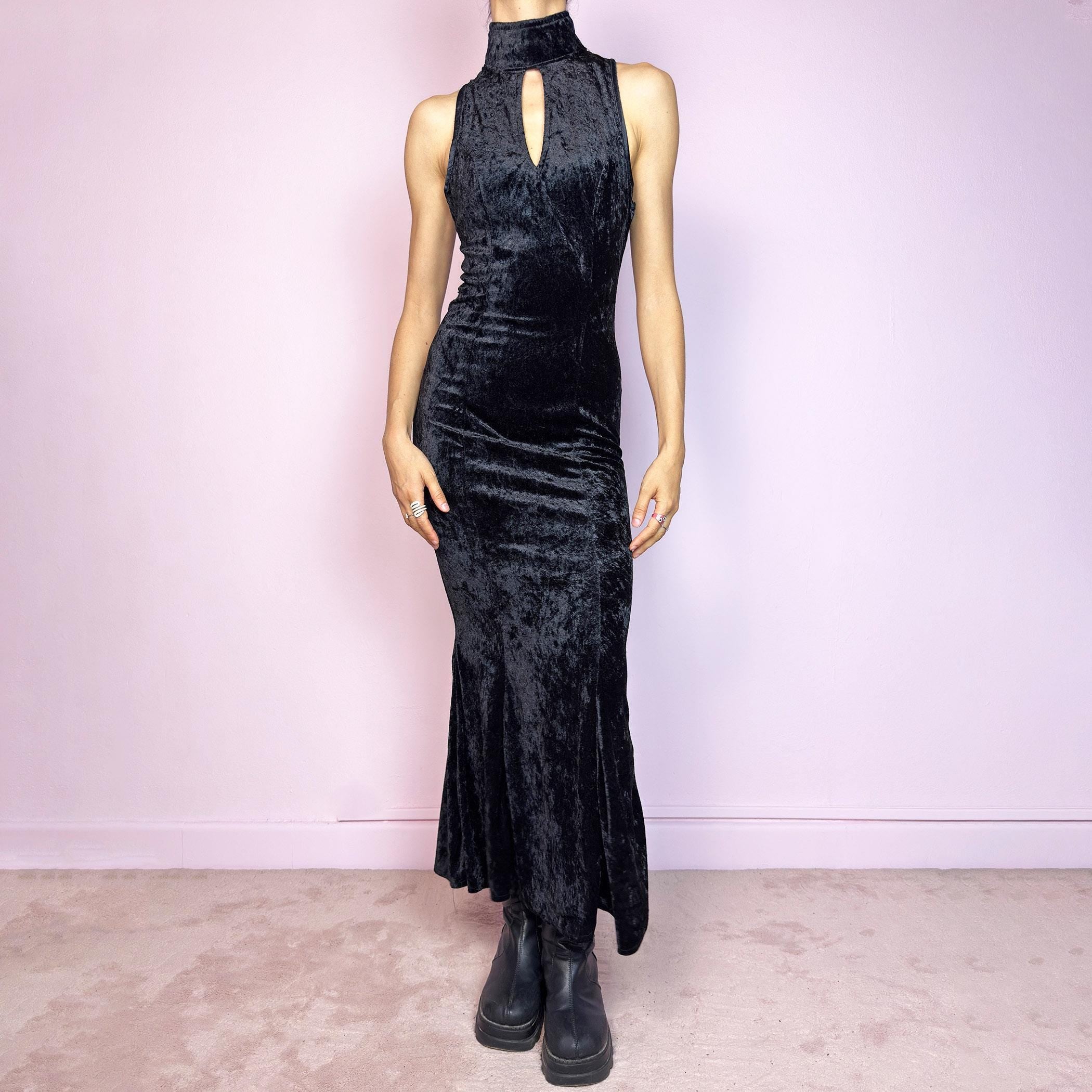 This vintage 90s black maxi dress is cut from plush stretch velvet with a sleeveless silhouette, mock neck, and front keyhole cut-out. Designed with a curve-hugging fit, ankle length, and back zipper closure. The soft texture and sculpted lines create bold contrast and gothic elegance. A sultry minimalist piece with timeless evening allure—perfect for formal events or moody romantic nights. Great vintage condition.