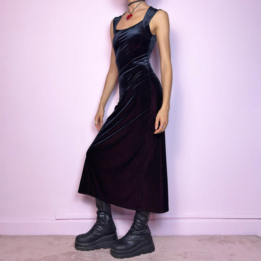 The Vintage 90s Black Velvet Midi Dress is pure elegance with a twist. Crafted from deep black velvet with a maroon undertone, it catches the light with rich, dark burgundy reflections that give it a luxe finish. Features wide straps, a square neckline, and a body-hugging midi silhouette that flatters and elongates. Soft and stretchy for comfort, yet bold and dramatic for gothic, romantic, or night-out looks. A subtly striking piece that stands out in movement and moonlight.