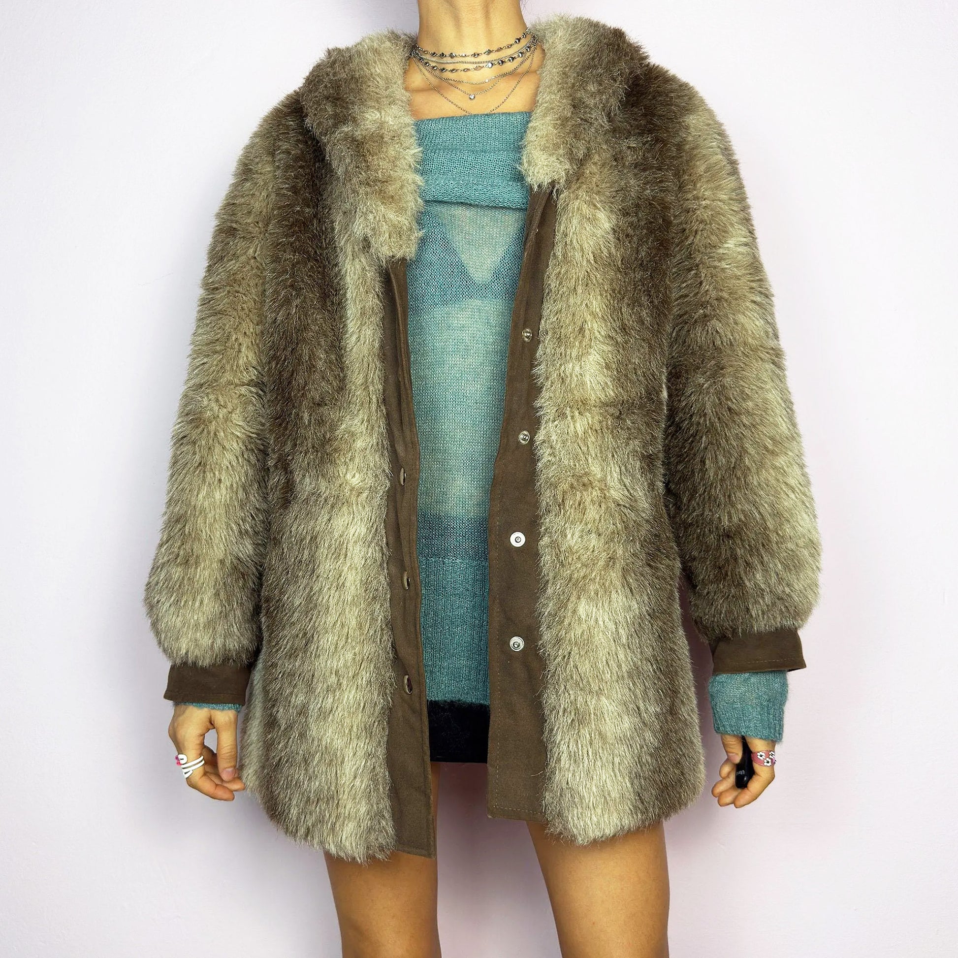 The Vintage 90s Plush Faux Fur Coat is a statement outerwear piece exuding warmth and glamour. This coat features a plush faux fur texture in earthy tones, creating a cozy look. Designed with a snap button-front closure, pockets and long sleeves, this coat is perfect for chilly days and for layering over casual or dressy outfits.