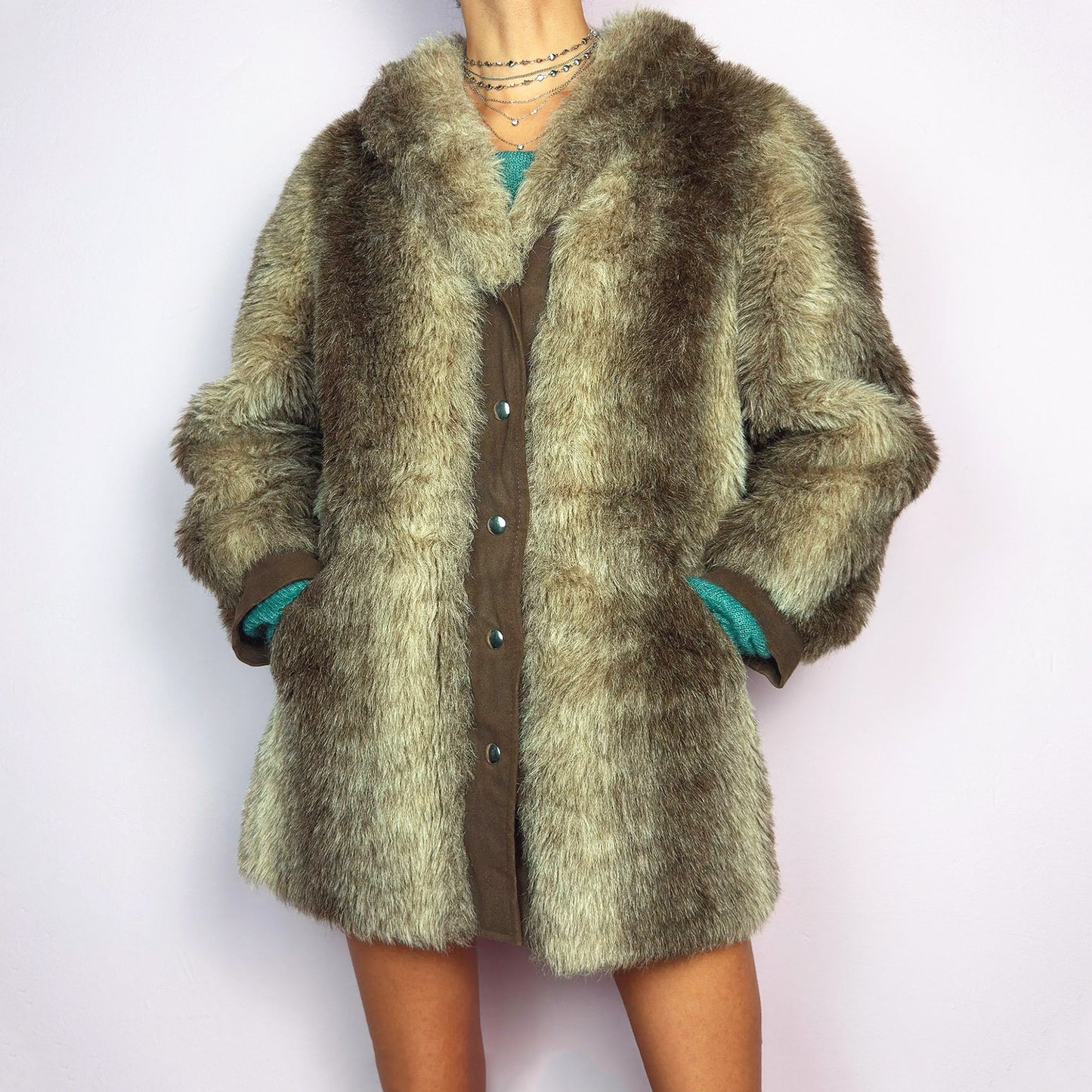 The Vintage 90s Plush Faux Fur Coat is a statement outerwear piece exuding warmth and glamour. This coat features a plush faux fur texture in earthy tones, creating a cozy look. Designed with a snap button-front closure, pockets and long sleeves, this coat is perfect for chilly days and for layering over casual or dressy outfits. Excellent vintage condition.