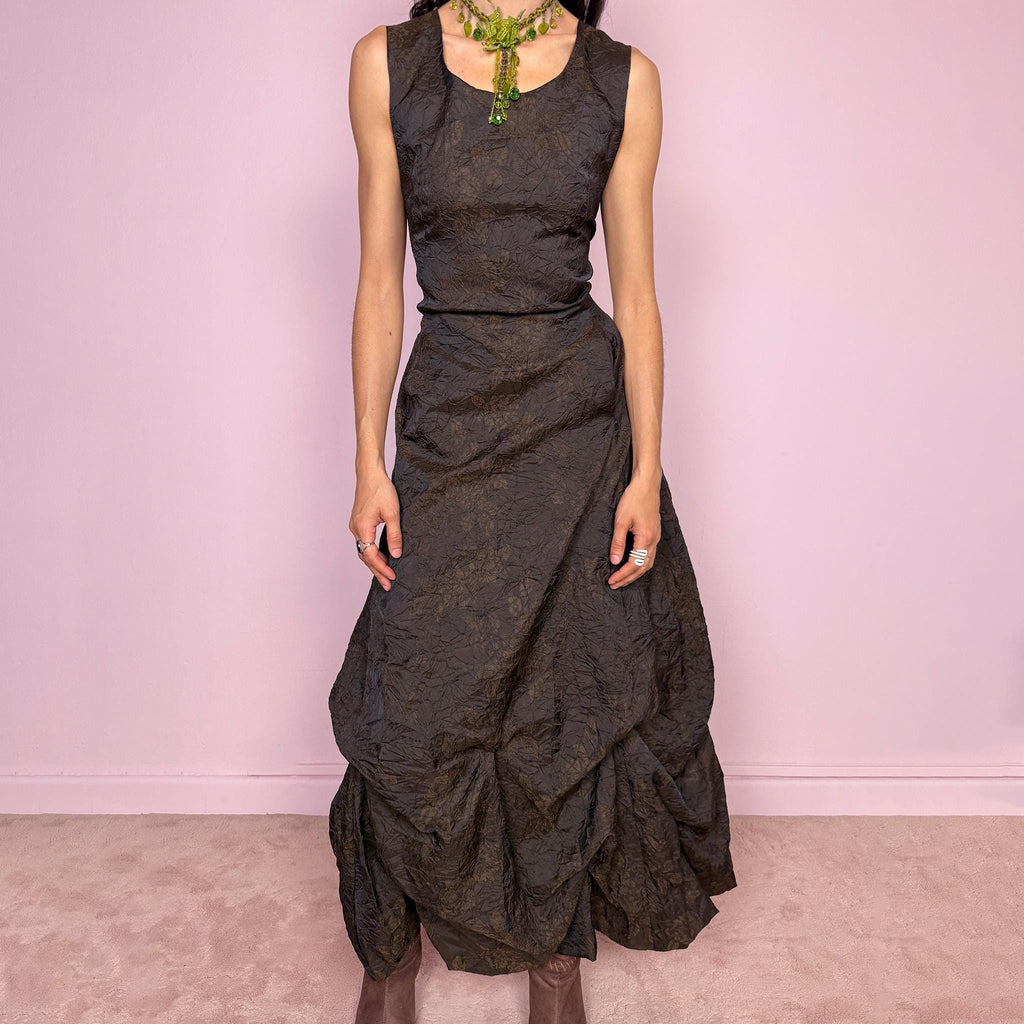 Vintage 90s dark brown sleeveless midi dress with a crinkle texture and subtle floral pattern. Features a voluminous draped balloon bubble hem and lace-up back for a fitted silhouette. Non-stretch design with avant-garde formal elegance, perfect for night events or statement evenings. Made in France from 50% acetate and 50% polyester. Excellent vintage condition.