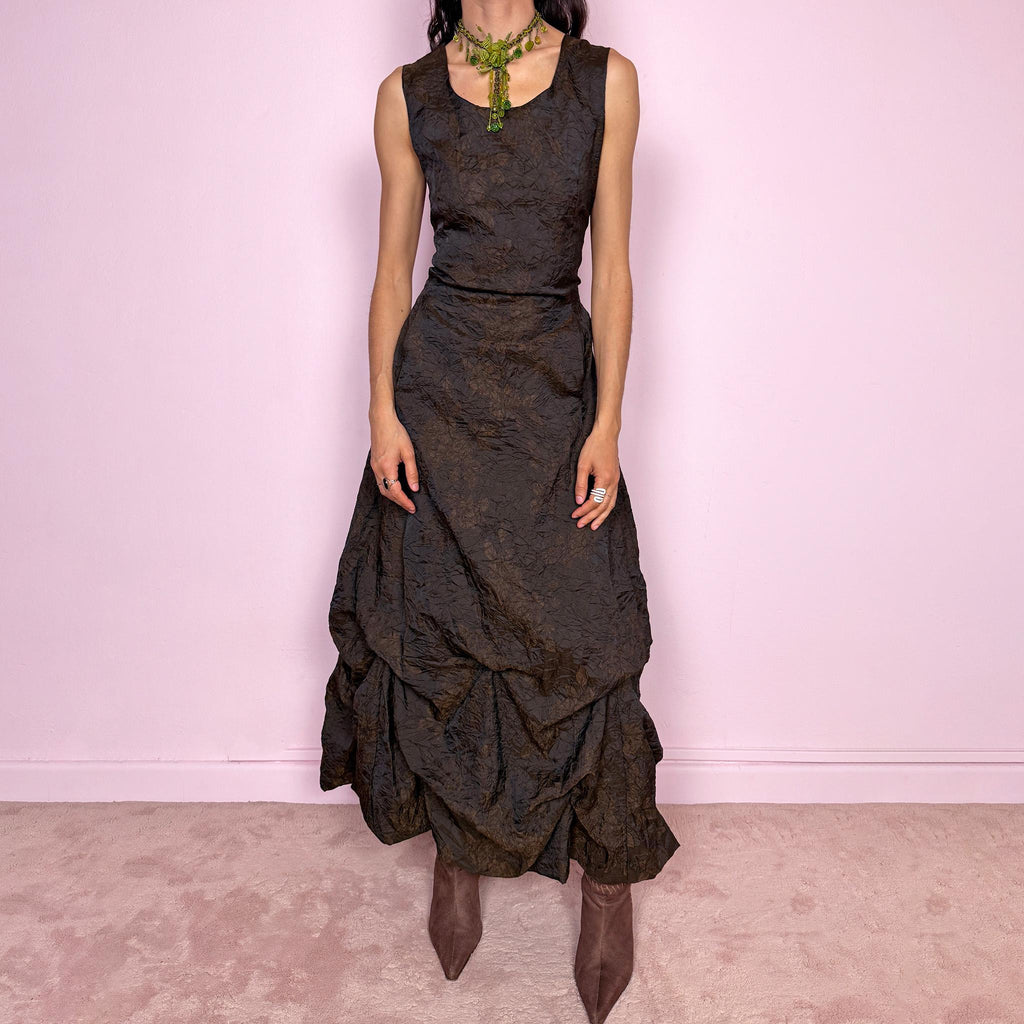 Vintage 90s dark brown sleeveless midi dress with a crinkle texture and subtle floral pattern. Features a voluminous draped balloon bubble hem and lace-up back for a fitted silhouette. Non-stretch design with avant-garde formal elegance, perfect for night events or statement evenings. Made in France from 50% acetate and 50% polyester. Excellent vintage condition.