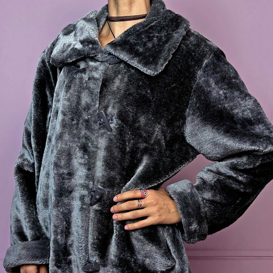 The Vintage 90s Gray Faux Fur Coat is a cozy and stylish outerwear piece featuring a plush faux fur design, a toggle-front closure, a wide collar, and pockets. Perfect for your winter wardrobe.