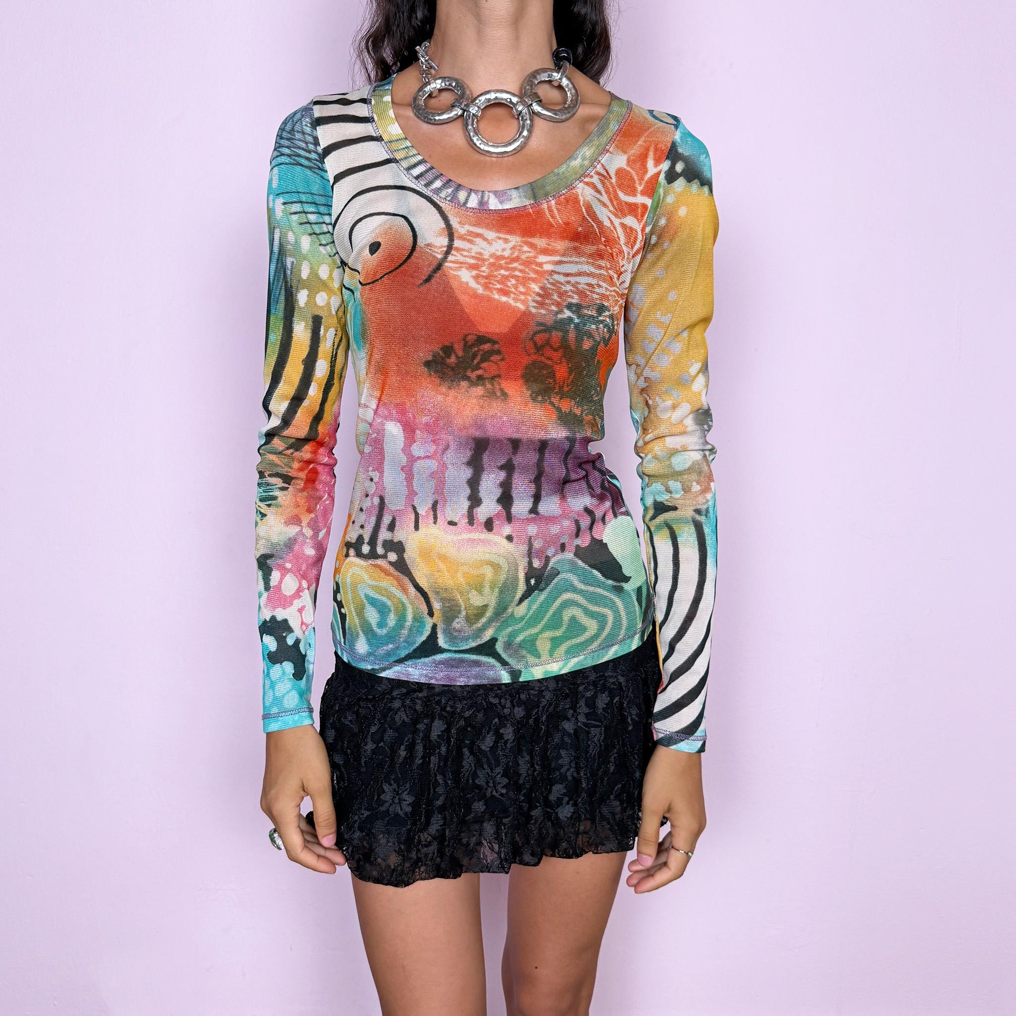 Vintage 2000s long-sleeve mesh top featuring a vibrant abstract graphic print mixing turquoise, orange, yellow, pink, and green with contrasting organic, striped, and painterly motifs. Designed with a fitted silhouette, scoop neckline, and semi-sheer lightweight mesh construction. Stretchy fabric creates a close, second-skin fit. A strong maximalist Y2K piece with an art-print feel. Made in France by a French brand from 100% polyester. Excellent vintage condition.