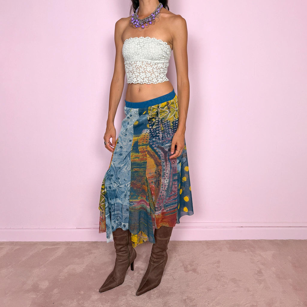 Vintage 2000s asymmetric mesh midi skirt crafted from lightweight, semi-sheer mesh with a fluid patchwork construction combining abstract graphic prints, painterly textures, and contrasting color panels in washed blue, yellow, orange, and earthy tones. Finished with an irregular handkerchief-style hem and layered inserts for a deconstructed, maximalist wearable-art Y2K silhouette.