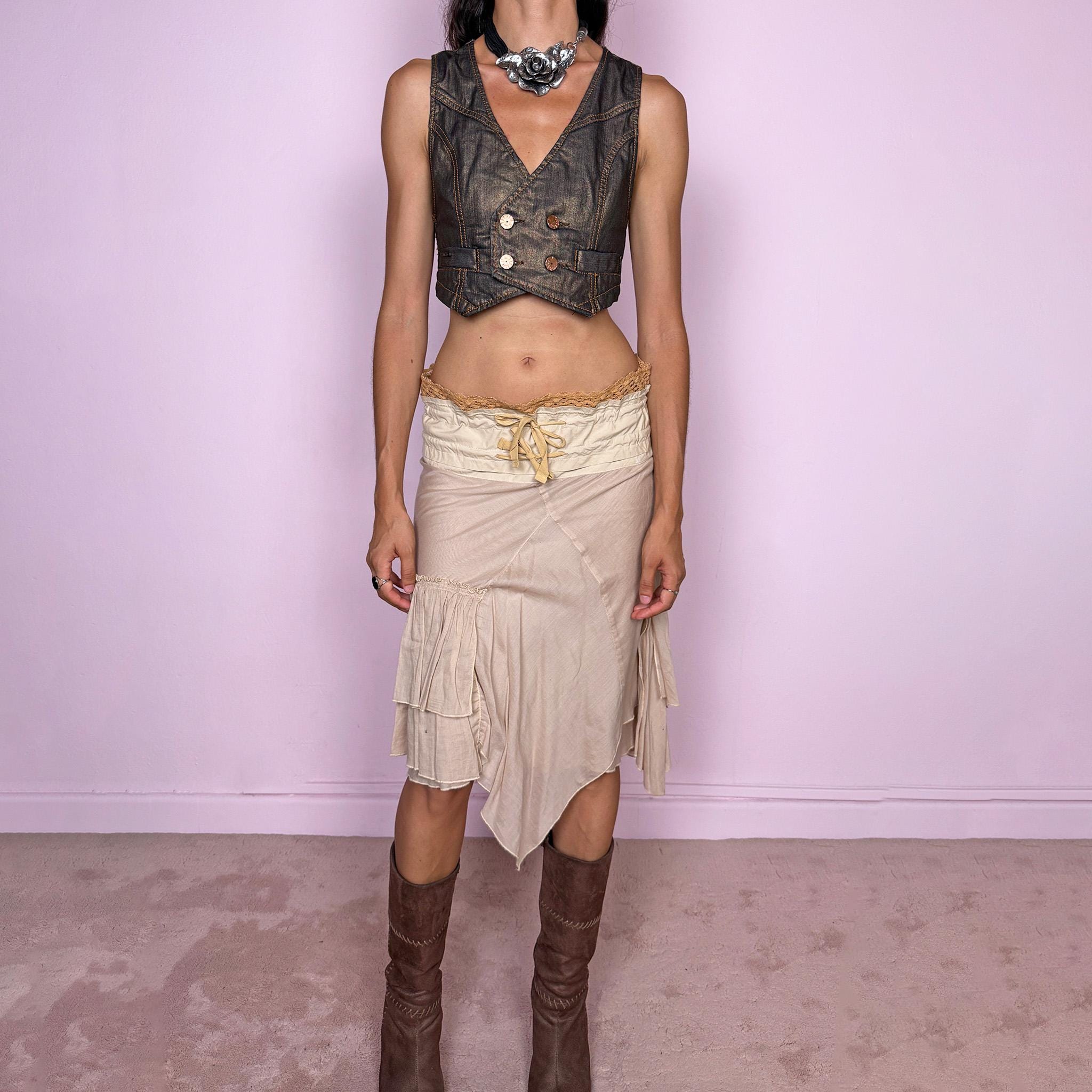 Vintage 2000s midi skirt, crafted from 100% cotton in a soft beige tone with a romantic low-rise silhouette and adjustable tie-front waist. Designed with a wide structured waistband, lace-up front detail, crochet-style trim along the top edge, and an asymmetric layered skirt with panel construction. A delicate bohemian Y2K piece with a deconstructed fairy summer feel. Very good vintage condition, with one small faint discoloured mark on the waistband, as shown in the last picture.