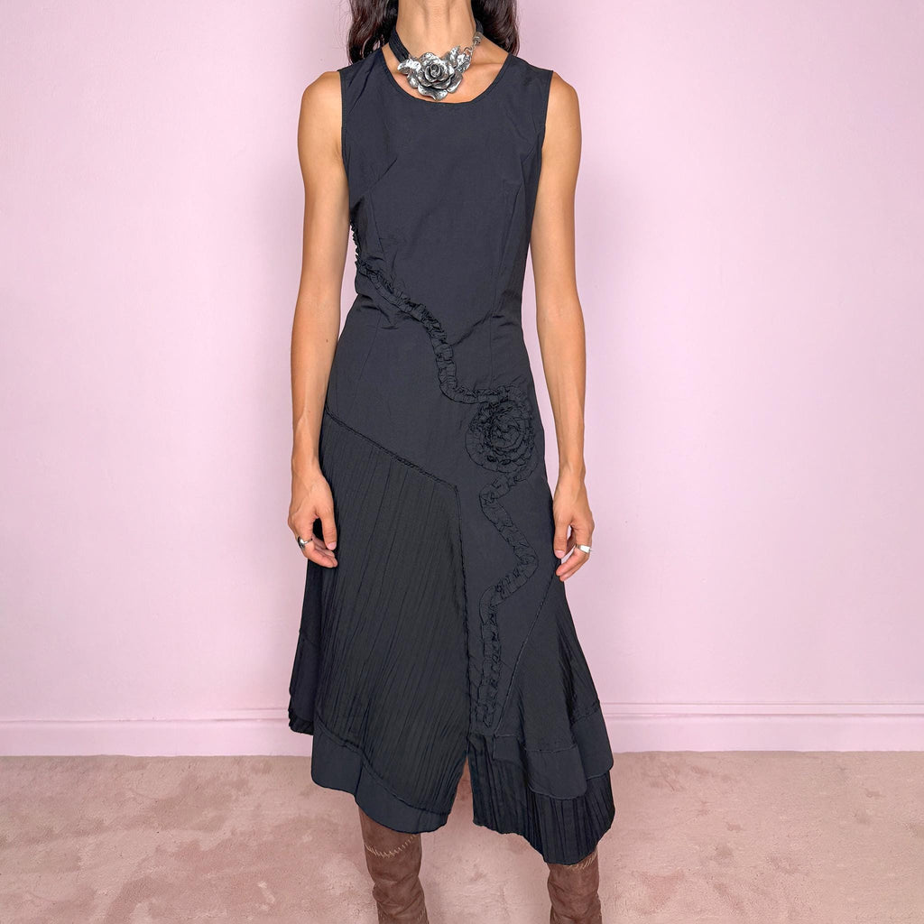 Vintage 2000s black asymmetric midi dress featuring a sleeveless silhouette with sculptural panel construction, mixed tonal textures, and ruffled trim creating an organic, deconstructed effect across the body. Finished with an irregular asymmetric hem and back zip closure. No stretch. For dark avant-garde looks. Made in France by a French brand. Main fabric: 61% viscose and 39% polyester. Other fabric: 54% cotton and 46% polyamide. Excellent vintage condition.