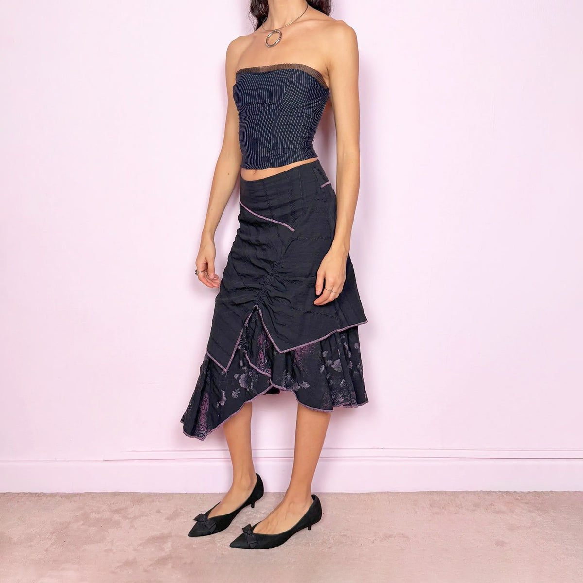Vintage 2000s black midi skirt with a deconstructed avant-garde design, featuring a ruched tie-drawstring front, layered construction, and a ruffled hem. Structured non-stretch fit with a back zip closure. Can be worn high-waisted for size S or slightly lower on the waist for sizes XS and XXS. Made in France by a Paris-based brand from a 65% cotton and 35% polyester blend. Great vintage condition.