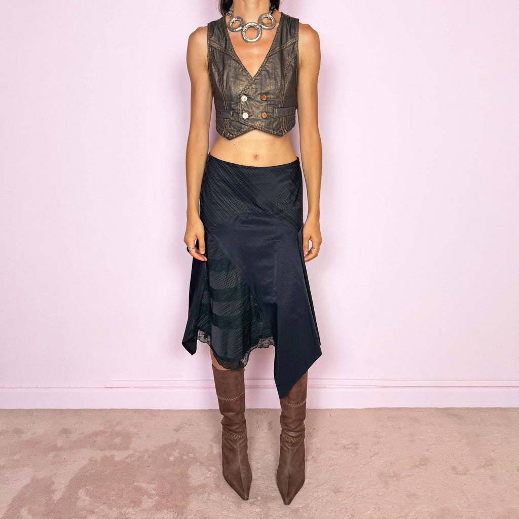 Vintage 2000s black asymmetric midi skirt featuring a deconstructed patchwork construction that combines fine pinstripe panels with contrasting fabric sections and subtle lace-trim detailing. Designed with a dramatic irregular handkerchief-style hem and a dark avant-garde Y2K silhouette. Features a side zip closure and no stretch. Can be worn high-waisted for size M or mid- to lower-rise for sizes S–XS.