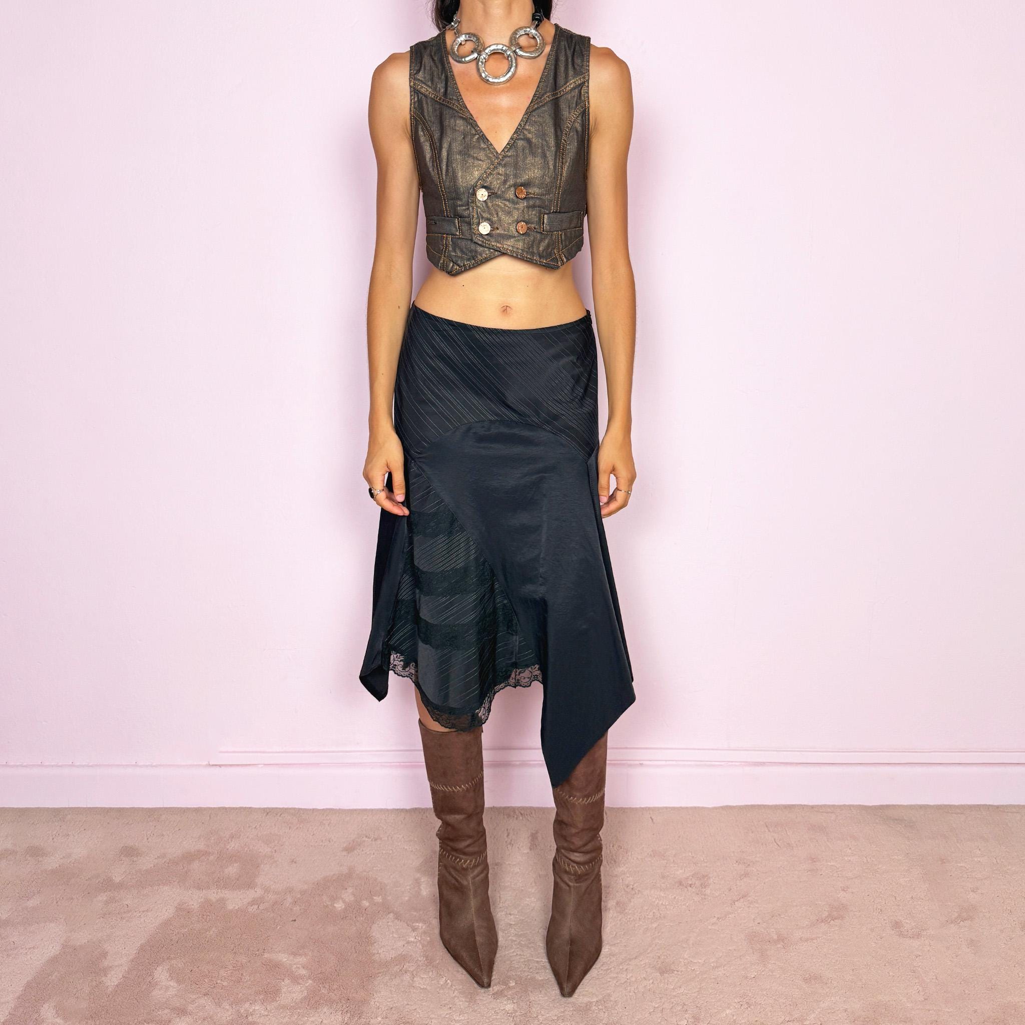 Vintage 2000s black asymmetric midi skirt featuring a deconstructed patchwork construction that combines fine pinstripe panels with contrasting fabric sections and subtle lace-trim detailing. Designed with a dramatic irregular handkerchief-style hem and a dark avant-garde Y2K silhouette. Features a side zip closure and no stretch. Can be worn high-waisted for size M or mid- to lower-rise for sizes S–XS.