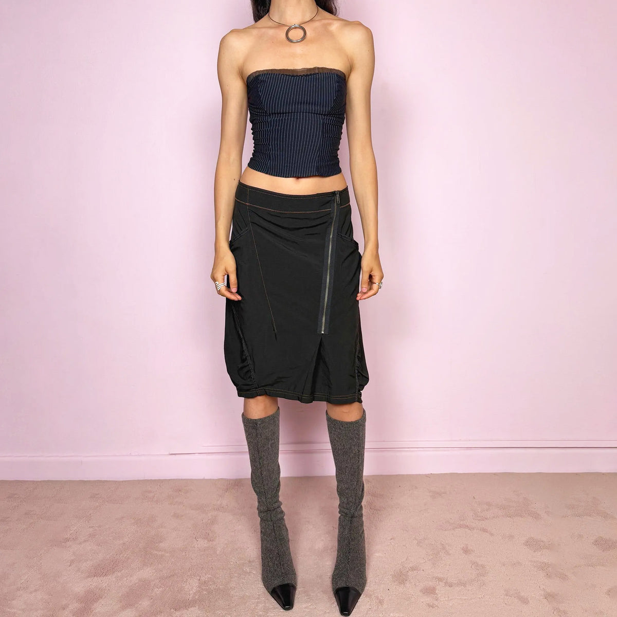 Vintage 2000s lightweight black midi skirt with a dark avant-garde, dystopian techwear look. Features pockets, an asymmetric front zip closure, ruched detailing, contrast topstitching, and a bubble hem effect. No stretch. Can be worn mid-rise for size L or lower-rise for size M. The composition label is missing, so the exact fabric is unknown. From a Dutch brand. Excellent vintage condition.