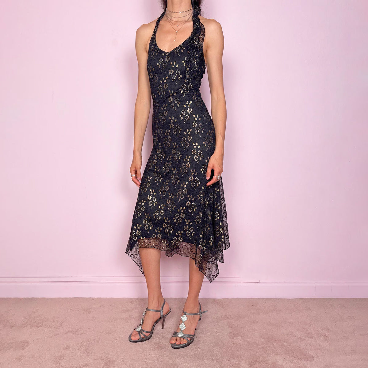 Vintage 2000s black backless halter midi dress with a V-neckline, stretchy fit, asymmetric handkerchief hem and lace mesh overlay with a gold floral pattern. Dark romantic statement piece for parties, nights out or elegant evening events. By a Spanish designer. Excellent overall condition.