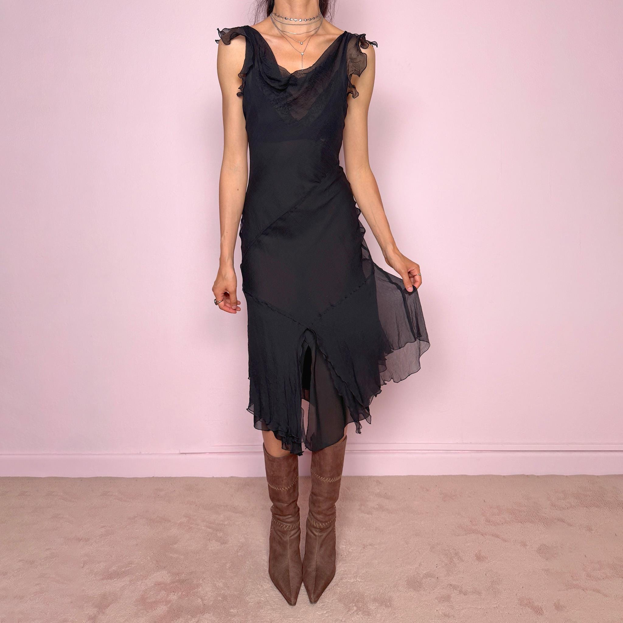 Vintage 2000s black midi dress with a romantic draped silhouette and semi-sheer layered construction. Designed with a cowl-style neckline, delicate ruffled cap sleeves, fitted waist, front slit detail, and fluid layered asymmetrical hem for an elegant dark evening look. The outer layer looks and feels like silk, but all labels are missing, so the exact fabric composition is unknown. Excellent vintage condition.