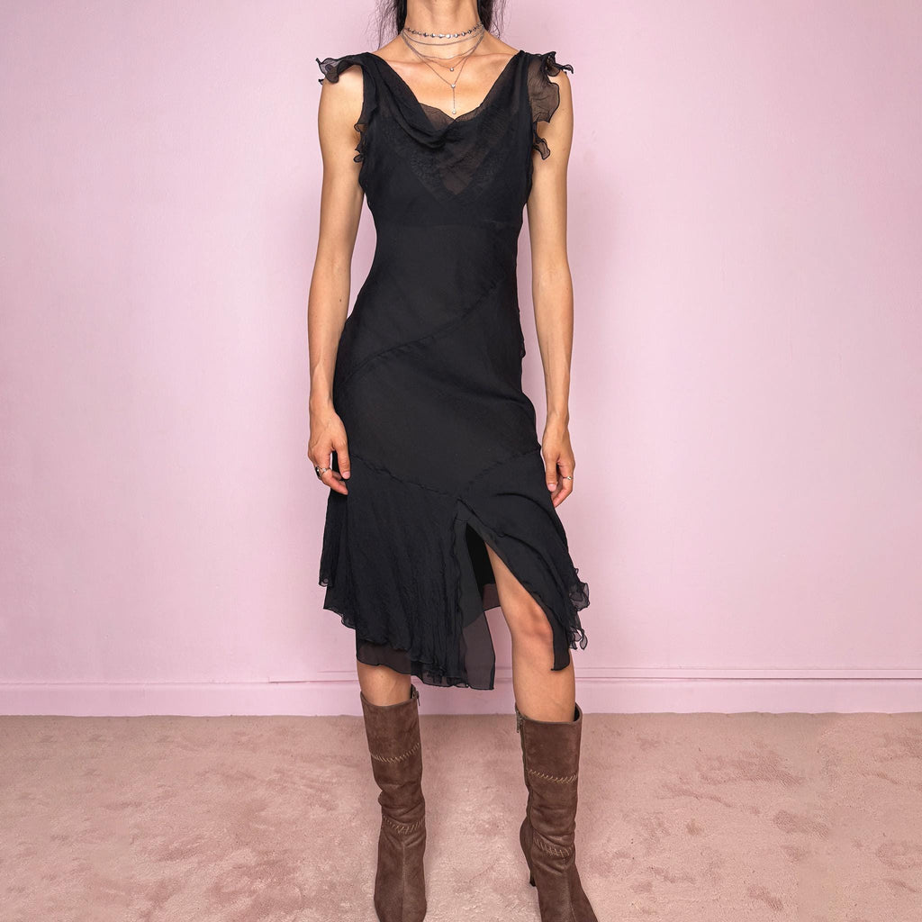 Vintage 2000s black midi dress with a romantic draped silhouette and semi-sheer layered construction. Designed with a cowl-style neckline, delicate ruffled cap sleeves, fitted waist, front slit detail, and fluid layered asymmetrical hem for an elegant dark evening look. The outer layer looks and feels like silk, but all labels are missing, so the exact fabric composition is unknown. Excellent vintage condition.