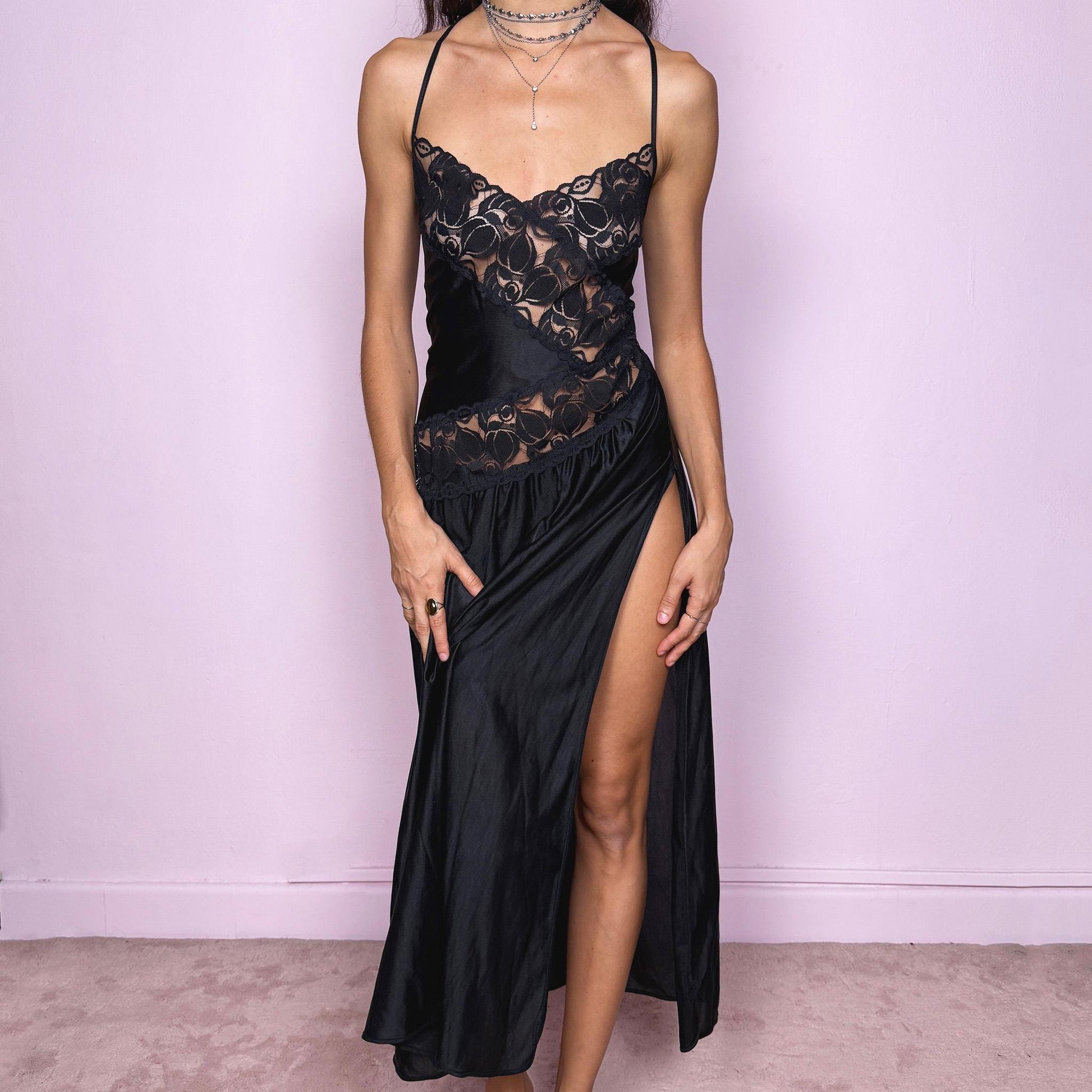 Stunning romantic vintage 2000s black long midi slip dress featuring lace details and an exaggerated side slit. The soft, fluid fabric creates a feminine, lingerie-inspired silhouette that works as a nightgown-style lounge piece, a date-night dress or an edgy night-out party look. The design has a refined, delicate and subtly seductive finish while remaining comfortable and wearable. Excellent vintage condition.