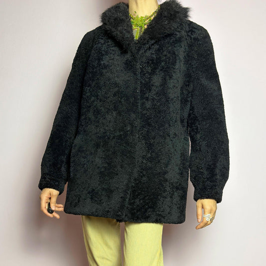 The Vintage Black Lamb Fur Coat is a luxurious, heavy statement piece made from lamb fur, featuring a plush texture. Designed with a boxy silhouette, it includes hidden hook closures and side pockets. The thick, weighty fur construction provides excellent insulation, making it perfect for cold weather and elegant winter styling. adult world shop